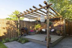 an outdoor patio with a wooden pergolan and potted plants