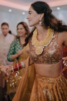 a woman in a gold outfit dancing with other people