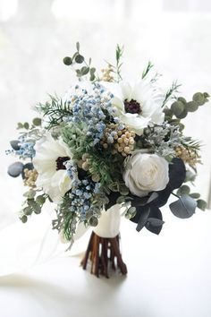 a bouquet of white and blue flowers on a table