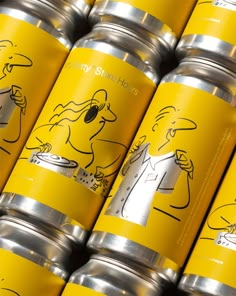 several yellow cans with drawings on them sitting next to each other