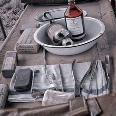 an outdoor picnic table is set up with silverware, wine bottle and other items