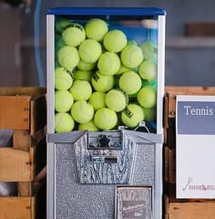 tennis balls are in an old fashioned vending machine