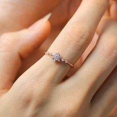 a woman's hand with a diamond ring on it