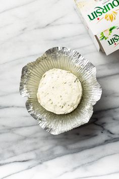 a box of unopened cheese sitting on top of a table next to a paper plate