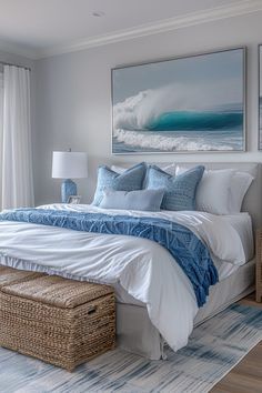 a bedroom with blue and white bedding, wicker storage baskets and paintings on the wall