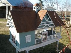 a doll house sitting in the middle of a yard