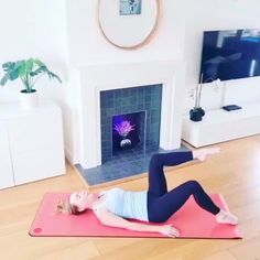 a woman is doing yoga in front of a fire place with her feet on the floor