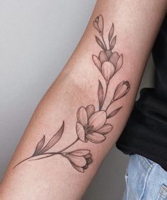 a woman's arm with a flower tattoo on the left side of her arm