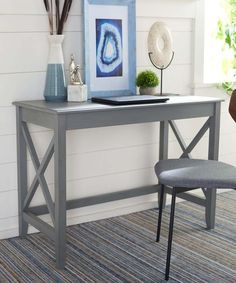 a desk with a chair next to it and pictures on the wall in front of it