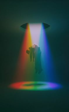 an image of a person in the air with a light coming from behind them that appears to be multicolored