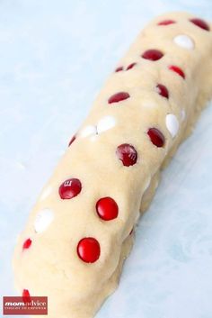 a long piece of food with red and white dots on it sitting on a blue surface