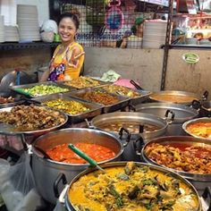 a woman standing in front of a table filled with lots of different types of food