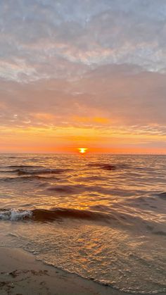 the sun is setting over the ocean with waves