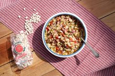 a bowl of food sitting on top of a table next to a bag of beans