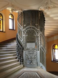 a spiral staircase in an old building with wrought iron railings