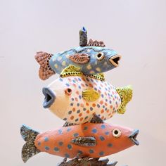 three ceramic fish sitting on top of each other