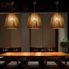 three lamps hanging from the ceiling above a wooden table with chairs and benches in front of it