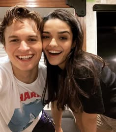 a young man and woman taking a selfie in front of a stove top oven