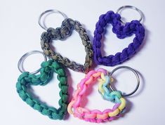 four heart shaped keychains are shown on a white surface