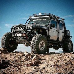 an off road vehicle driving on rocks in the desert