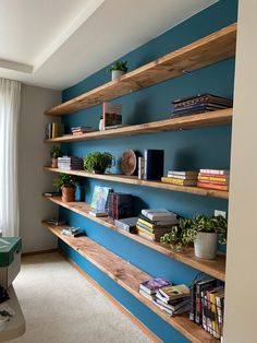 a room with blue walls and shelves filled with books, plants, and other items