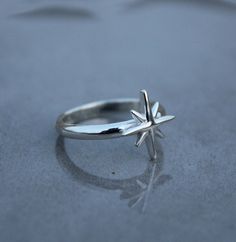 Introducing our stunning silver ring adorned with a captivating star design, perfect for those who seek celestial elegance. This North Star Ring, also known as the Starburst Ring or Pole Star Ring, showcases a dainty star that adds a touch of celestial charm to any outfit. Crafted with meticulous attention to detail, this astrology-inspired piece is a must-have for those who appreciate the beauty of the night sky. Made from high-quality silver, this nautical star ring is a timeless accessory that will effortlessly elevate your style. PRODUCT DETAILS - Material - Silver Ring Size - All Ring Size Available DELIVERY SERVICES- USPS for US Buyers 8-12 Working Days EVRI  for  UK  Buyers 8-12 Working Days IndiaPost International for Other Countries  10-15 working days Dispatched Within 1-3 workin Celestial Style, Starburst Ring, Silver Celestial Style Ring, North Star Ring, Celestial Silver Ring Jewelry, Celestial Silver Star Midi Rings, Sterling Silver Star Midi Ring, Celestial Star-shaped Midi Rings As Gift, Silver Celestial Metal Ring