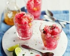 three glasses filled with ice cream on top of a white plate next to spoons