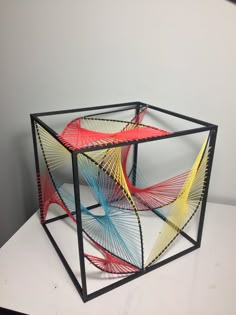 an artistic sculpture made out of wire and plastic on top of a white countertop