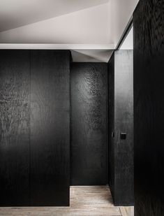 an empty room with black walls and wooden floors is seen in this image from the inside