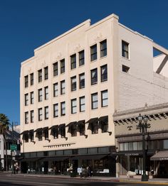 an old building on the corner of a street with palm trees in front of it