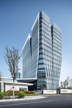 a very tall building sitting on the side of a road in front of a tree