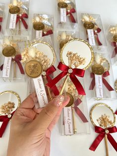 a person is holding up some gold and red flowers in front of other small boxes