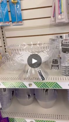 a store shelf filled with clear plastic cups and bowls on top of each other, next to toothbrushes