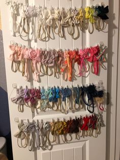 a bunch of different colored bows hanging on a door