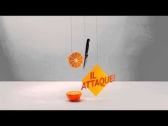 an orange being suspended by two strings with the word attaque written on it