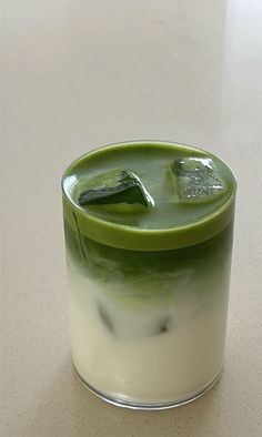 a green drink in a glass on a table