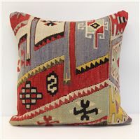 a multicolored decorative pillow on a white background with an arrow and cross design