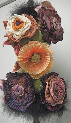 an arrangement of flowers and feathers on a table