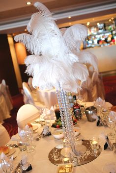 a white table topped with lots of tables covered in white cloths and place settings