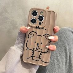 a woman holding up a phone case with a drawing on it's back cover