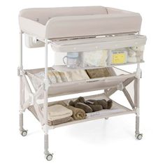 a white baby changing table with two shelves on each side and various items in the bottom drawer