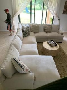 a living room filled with lots of furniture and a large white couch next to a window