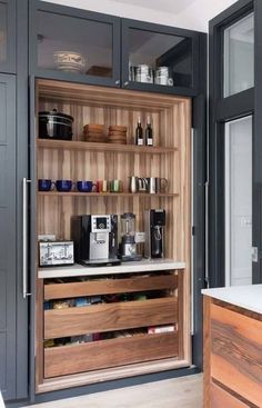 a kitchen with wooden shelves filled with coffee machines