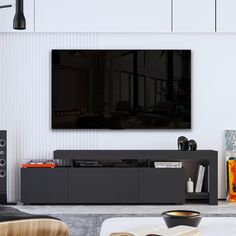 a living room with a large flat screen tv mounted on the wall above it's entertainment center