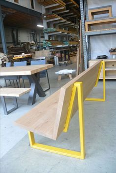 a wooden bench sitting in the middle of a room filled with tables and benches,