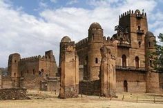 an old castle sits in the middle of a field