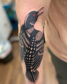 a black and white bird tattoo on the leg