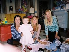 three women and a baby are sitting on the floor