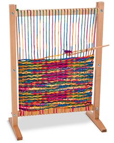 a weaving machine with colorful yarn and wooden frame on white background, close up view