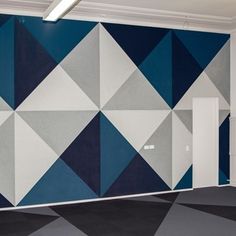 an empty room with blue and grey geometric wallpaper